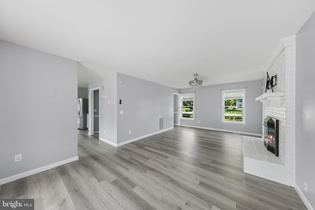 5983 Ridge Spring Cir, Salisbury, MD 21801 - unfurnished living room with a brick fireplace, wood finished floors, and baseboards
