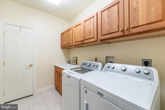 laundry area featuring a sink, cabinet space, light tile patterned flooring, and washer and dryer