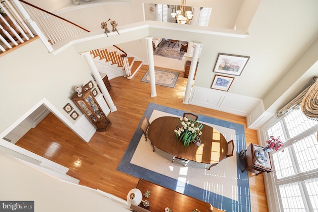 foyer featuring a high ceiling, wood-type flooring, stairs, and a notable chandelier