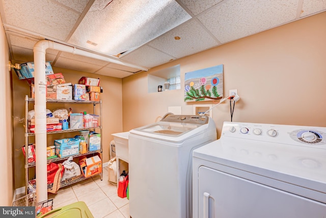laundry room featuring washing machine and clothes dryer, laundry area, and light tile patterned floors