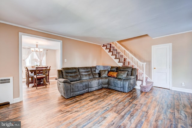 living room featuring wood finished floors, radiator, crown molding, and stairs
