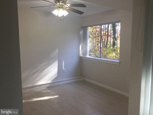 unfurnished room featuring baseboards and a ceiling fan