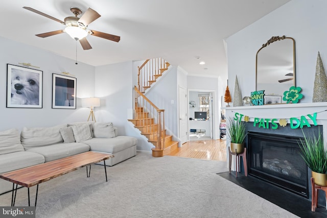 living area featuring ceiling fan, stairway, a fireplace with flush hearth, carpet flooring, and recessed lighting