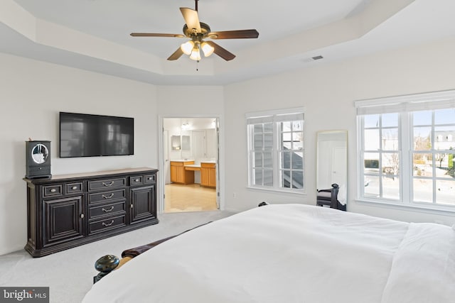 bedroom with visible vents, connected bathroom, baseboards, carpet, and a tray ceiling