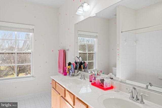 full bathroom with a sink, a wealth of natural light, and double vanity