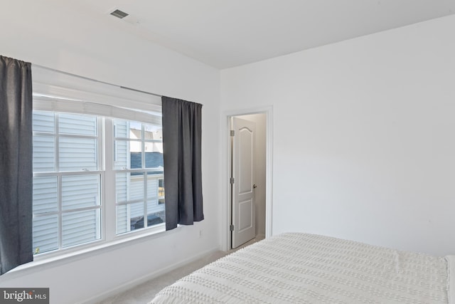 bedroom with visible vents, carpet floors, and baseboards