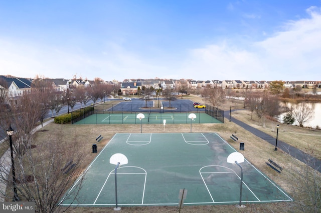 view of basketball court featuring a residential view, community basketball court, and fence