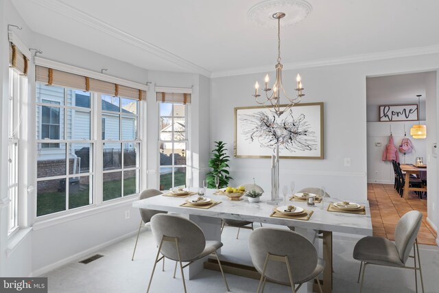 dining room featuring an inviting chandelier, crown molding, baseboards, and visible vents