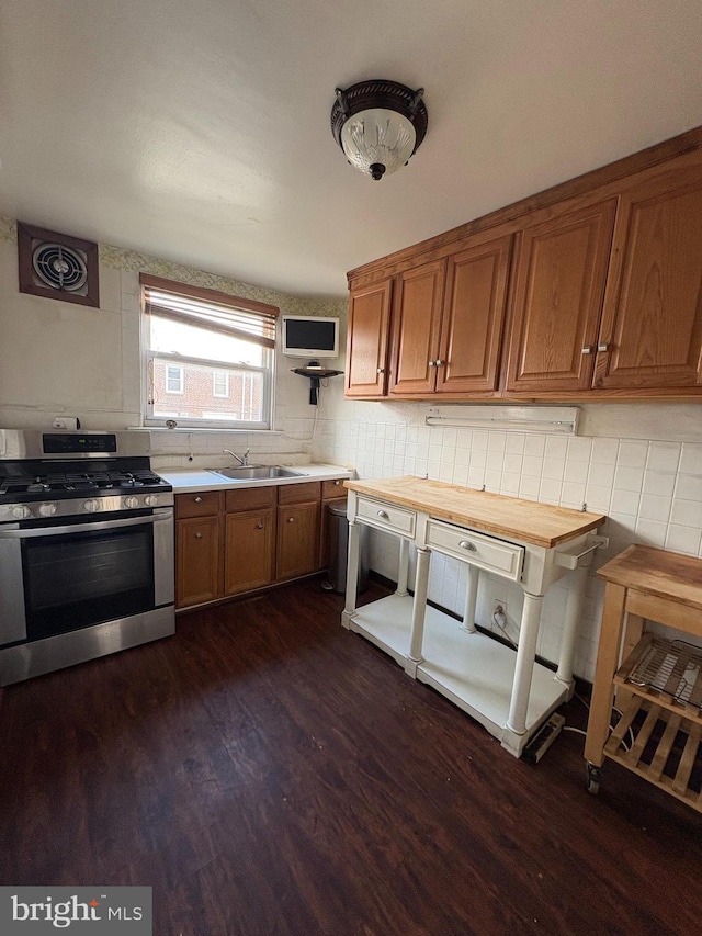 1536 E Pastorius St, Philadelphia, PA 19138 - kitchen featuring brown cabinets, stainless steel range with gas stovetop, dark wood-type flooring, and a sink