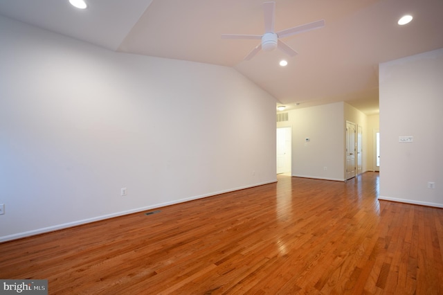 spare room featuring light wood-type flooring, a ceiling fan, vaulted ceiling, recessed lighting, and baseboards