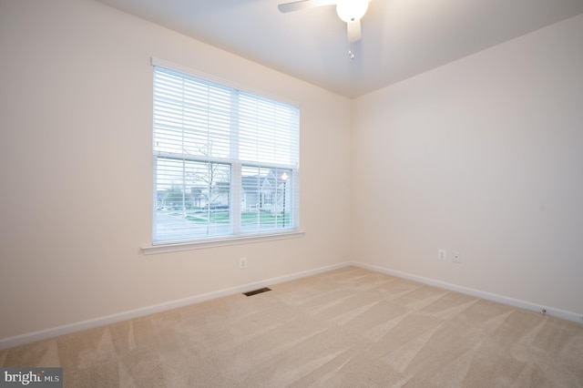 unfurnished room with visible vents, baseboards, ceiling fan, and light carpet