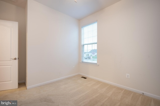 carpeted empty room featuring baseboards and visible vents