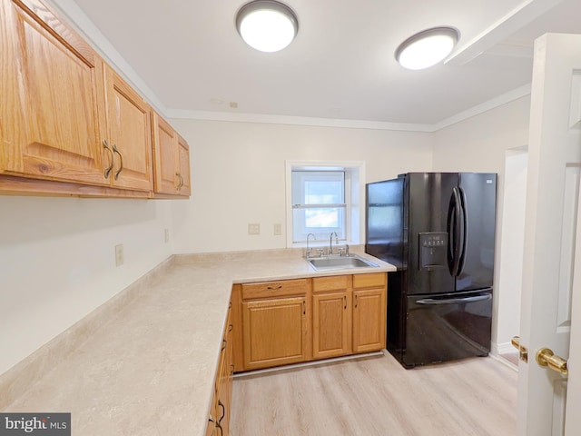 kitchen featuring light wood-style floors, black refrigerator with ice dispenser, ornamental molding, and a sink