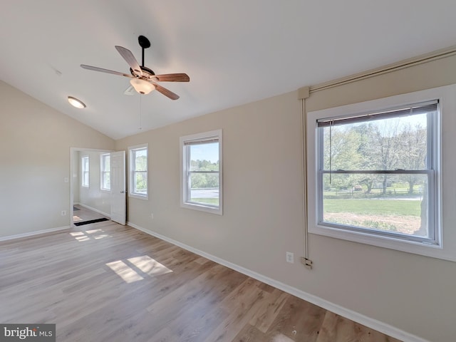 empty room with lofted ceiling, ceiling fan, light wood-type flooring, and baseboards