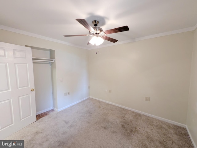 unfurnished bedroom featuring crown molding, a closet, and carpet