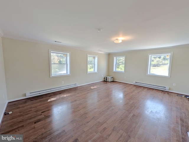 unfurnished room with ornamental molding, baseboard heating, and wood finished floors