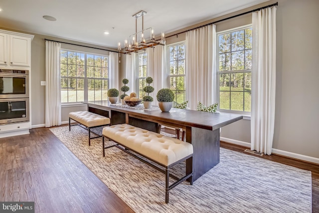 dining space featuring an inviting chandelier, baseboards, and dark wood-style flooring