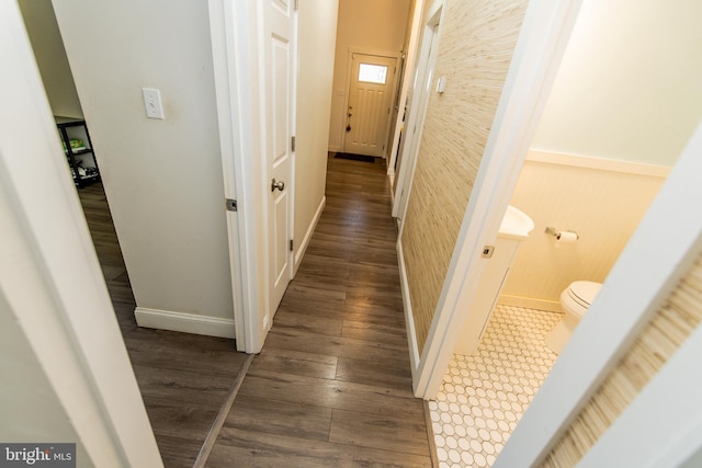 hall with baseboards and wood finished floors