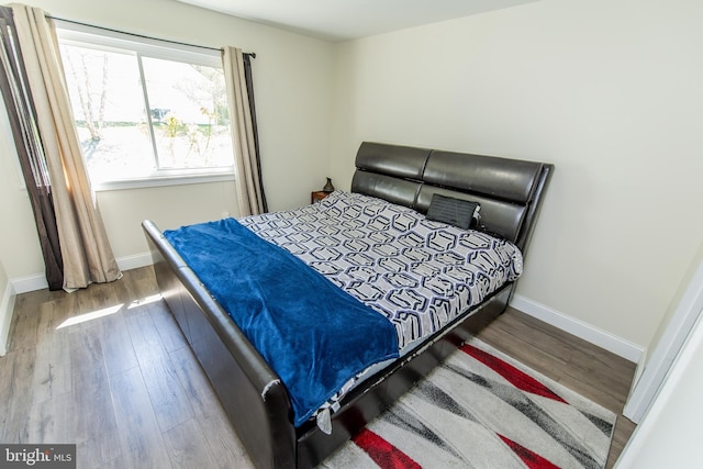 bedroom with baseboards and wood finished floors