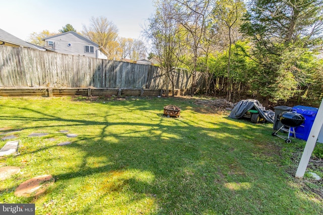 view of yard with an outdoor fire pit and a fenced backyard