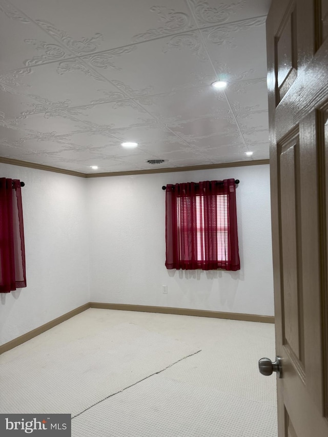 carpeted spare room with recessed lighting, baseboards, and ornamental molding