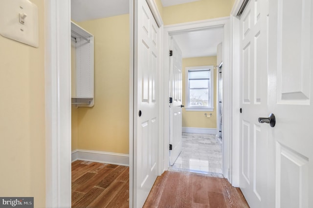 hallway featuring baseboards and wood finished floors