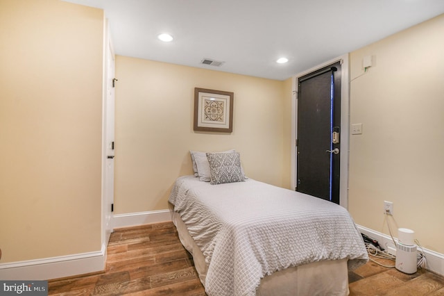 bedroom with recessed lighting, baseboards, visible vents, and wood finished floors