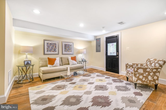 living area with visible vents, electric panel, baseboards, wood finished floors, and recessed lighting