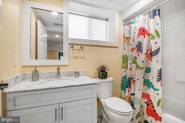 bathroom featuring visible vents, toilet, vanity, and shower / bath combo