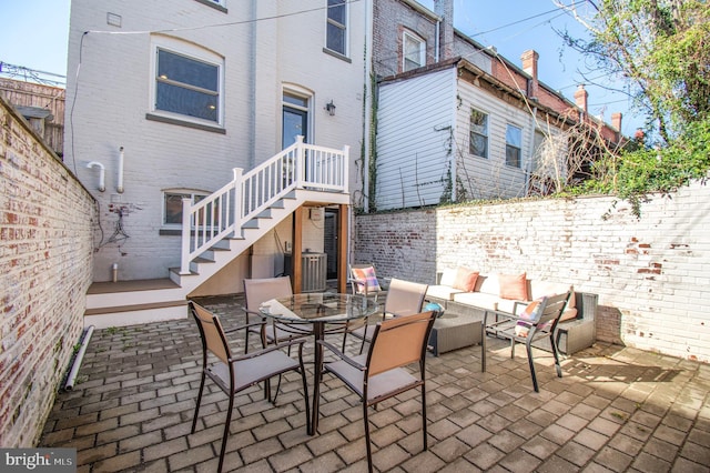 view of patio / terrace with fence, outdoor dining space, and stairway