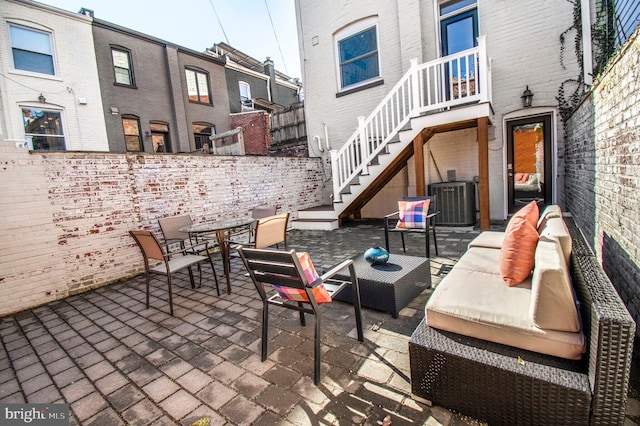 view of patio / terrace with stairs, outdoor dining area, and central AC