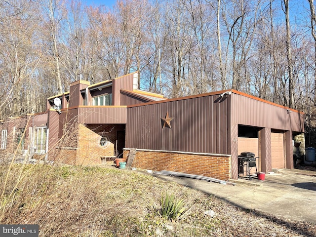 view of home's exterior featuring brick siding and a garage