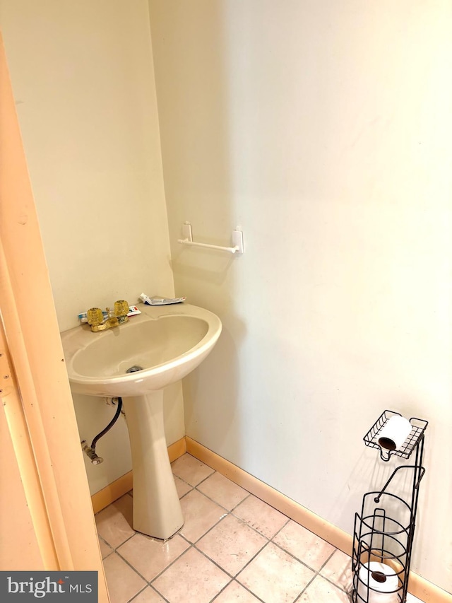 bathroom with baseboards and tile patterned floors