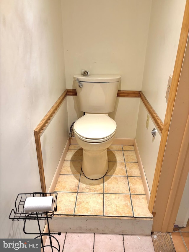 bathroom featuring tile patterned floors, toilet, and baseboards