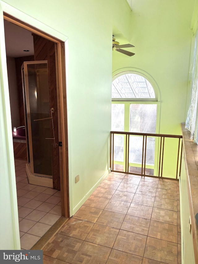 corridor with tile patterned floors and baseboards