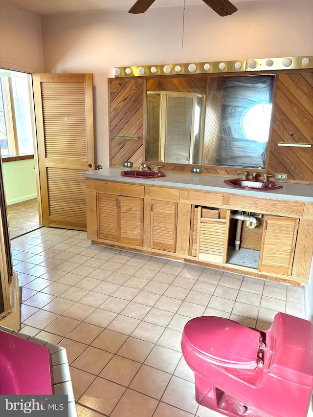 bathroom featuring a ceiling fan, a sink, a stall shower, and tile patterned floors