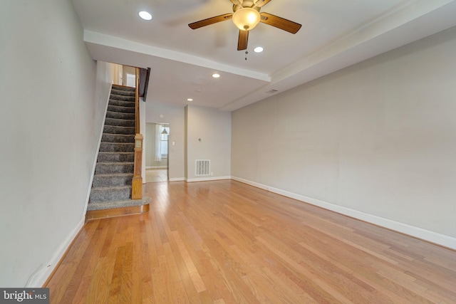 unfurnished living room featuring stairs, visible vents, baseboards, and light wood-type flooring