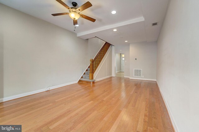 unfurnished living room featuring visible vents, stairway, baseboards, and light wood-style floors