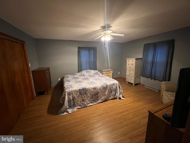 10917 Kemper Dr, Williamsport, MD 21795 - bedroom featuring a baseboard heating unit, wood finished floors, and ceiling fan