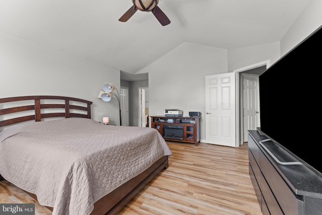 bedroom featuring light wood-type flooring, vaulted ceiling, and a ceiling fan
