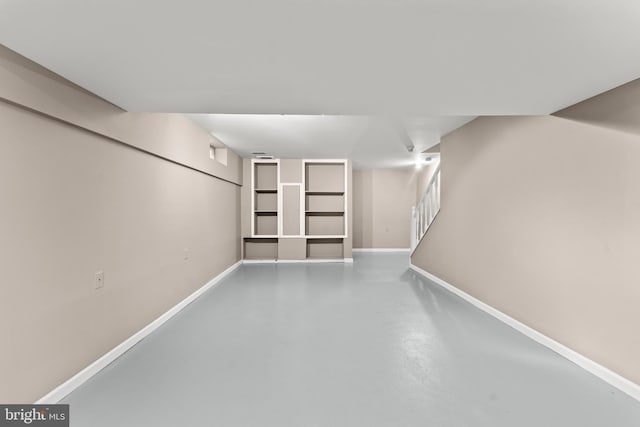 finished below grade area featuring stairway and baseboards