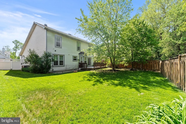 back of house featuring a lawn and a fenced backyard