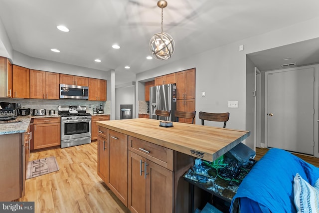 kitchen with light wood-style flooring, wood counters, backsplash, appliances with stainless steel finishes, and recessed lighting