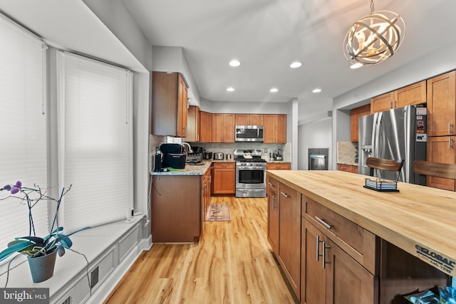 kitchen with light wood-style floors, butcher block countertops, appliances with stainless steel finishes, decorative backsplash, and recessed lighting