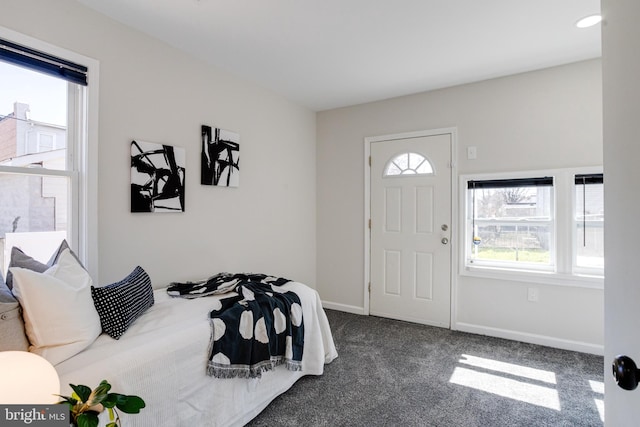 bedroom with baseboards and dark carpet