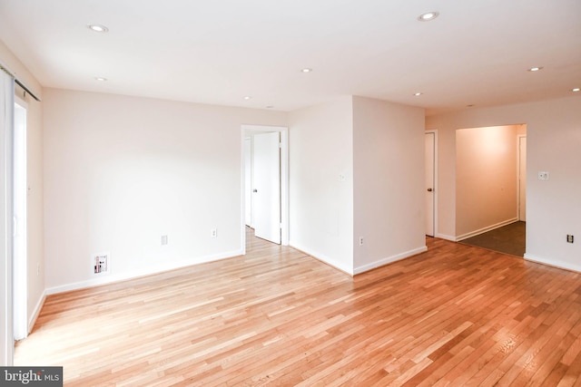 empty room with recessed lighting, light wood-style flooring, and baseboards