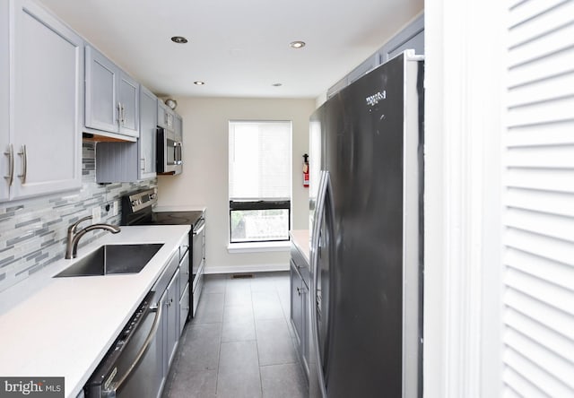 kitchen featuring tile patterned flooring, decorative backsplash, recessed lighting, a sink, and stainless steel appliances