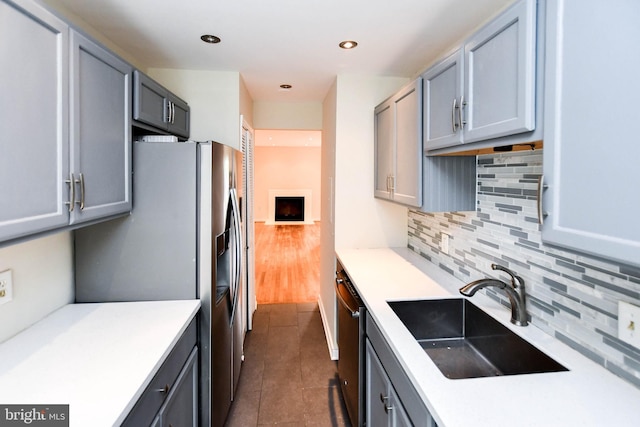kitchen featuring light countertops, a sink, tasteful backsplash, and stainless steel appliances