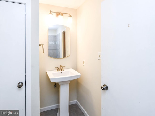 bathroom featuring baseboards and a sink