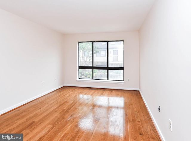 spare room with light wood-style floors and baseboards